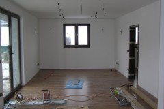 22) Interiér po pokládce laminátové plovoucí podlahy a následné instalaci obložkových zárubní.